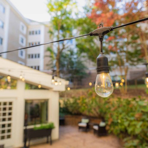 String lights over the Tall Oaks patio at dusk
