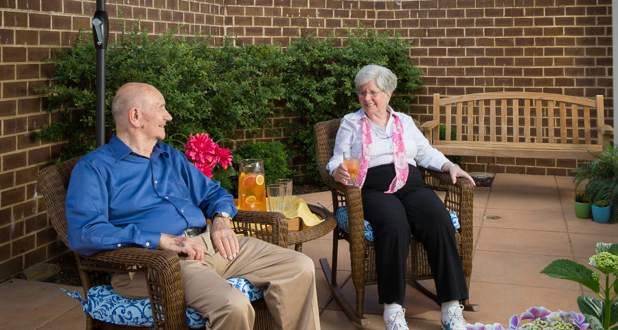 Assisted living residents sitting on side porch.